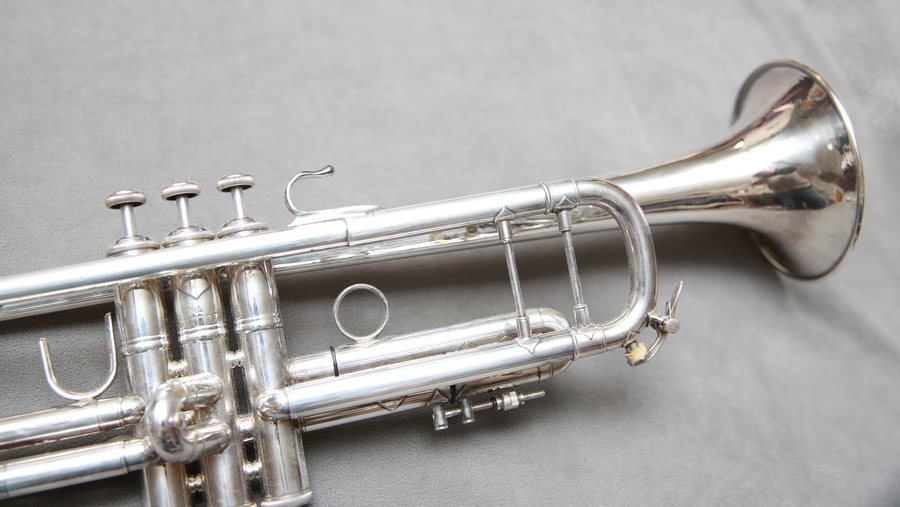 A silver trumpet on a gray background